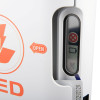 Close‑up of AED status window showing battery, pad, and fault indicators next to an orange “OPEN” arrow.