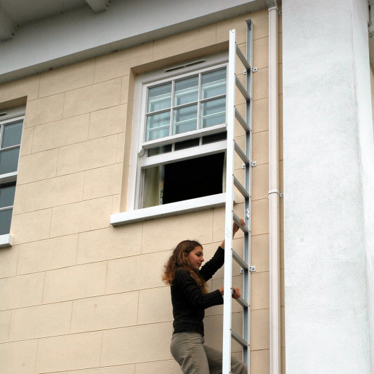 Saffold Fold Out Fire Escape Ladder Child installed outside a window with a person climbing down the ladder