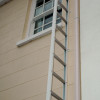 Saffold Fold Out Fire Escape Ladder installed on exterior wall reaching a first-floor window