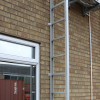 Saffold Fold Out Fire Escape Ladder open on wall next to a window on a brick building