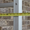 Measuring tape showing open width of Saffold Fold Out Fire Escape Ladder against a brick wall background