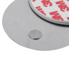 Closeup of the magnetic alarm mounting kit showing round metal parts and adhesive backing on a flat surface