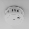 White smoke alarm mounted on a ceiling using the magnetic alarm mounting kit in situ