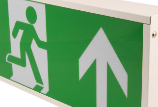 close up of green and white self testing emergency exit sign