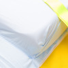 spectrum healthcare resqmat showing a close-up of a pillow with light blue fabric on a yellow surface