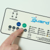 a finger pressing a button on the control panel of the ultraguard personal fire protection system