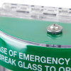 Close-up detail of green sti flush mounted call point cover with silver screw and partial white text on curved surface