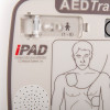 Close-up of an AED Trainer front panel showing a diagram of electrode pad placement on the chest and branding for the iPAD model
