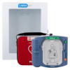 A Philips HeartStart AED sits next to its red carrying case, both positioned in front of a white wall‑mounted Cardiact cabinet. The blue defibrillator shows a pull handle and a diagram illustrating correct pad placement on the chest.