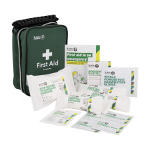 st john home kit showing a green zippered first aid bag and various medical supplies including dressings and gloves
