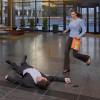 Woman running carrying an orange Cardiac Science Defibrillator in a building lobby
