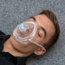 Front view of a person wearing a St John Ambulance rescue mask over the nose and mouth