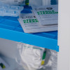 closeup of interior blue shelf in st john ambulance first aid cabinet with key showing small medical supplies