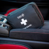st john bs85992 motoring kit small black first aid pouch with white cross resting on car centre console armrest