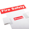 Close up of a fire log book wall holder showing red and white labels that read Fire Safety and Missing