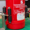 Close-up of an ultrafire extinguisher servicing clamp holding part of a red extinguisher on a work surface