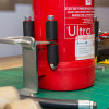 Ultrafire extinguisher servicing clamp holding a red extinguisher upright on a workbench