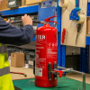 Ultrafire extinguisher servicing clamp securing a fire extinguisher while a person inspects the hose