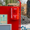 Red site alarm attached to a red site stand with waterproof cabinet shown outdoors on a worksite
