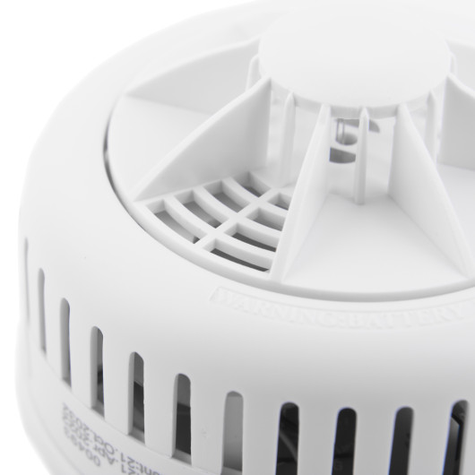 Close up of the test hush button on an ultra fire heat alarm showing the white plastic details