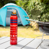 ultrafire 600g powder extinguisher standing on a table next to a barbecue with a blue tent and camping chair in the background