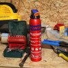 ultrafire 600g powder extinguisher standing upright on a wooden workbench in a workshop with tools and equipment around it