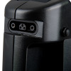 Close‑up of a three‑pin electrical connector recessed into a textured black device housing with a visible screw on the side.