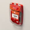 Red Sigma Smart+Guard call point cover flush mounted on a wall with a clear plastic sounder cover showing insitu installation