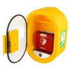 A yellow wall‑mounted cabinet with a clear locking door containing a red Philips HeartStart defibrillator case marked with a white heart and lightning bolt symbol. A green defibrillator station sticker is visible on the cabinet.