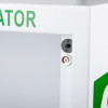 Close‑up of a white metal cabinet corner showing a black fastener and a silver Phillips screw, with partial green lettering visible.