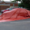 bridgehill single use car fire blanket deployed over a car from the side view in an outdoor parking area