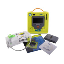 A bright green defibrillator with a large grey LCD screen and its contents