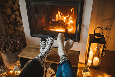 Feet up relaxing in front of a log burner